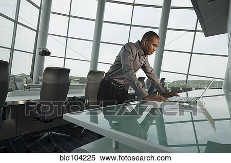 Black businessman using laptop in conference room View Large Photo Image Stock Photography - Black businessman using laptop in conference room. Fotosearch