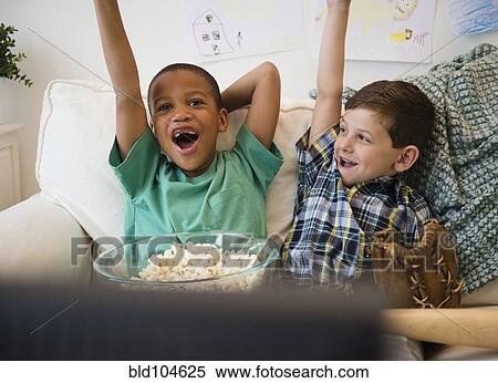 Boys eating popcorn and cheering View Large Photo Image Stock Photography - Boys eating popcorn and cheering. Fotosearch