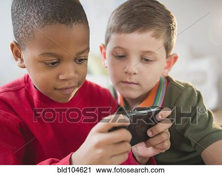 Boys looking at cell phone together View Large Photo Image Stock Image - Boys looking at cell phone together. Fotosearch