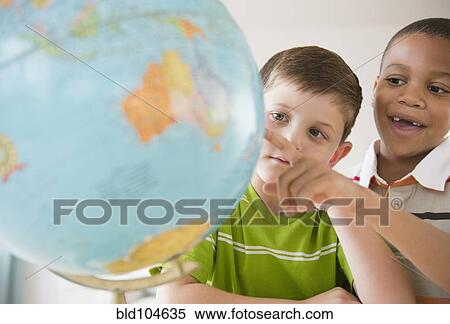 Boys looking at globe together View Large Photo Image Stock Photography - Boys looking at globe together. Fotosearch