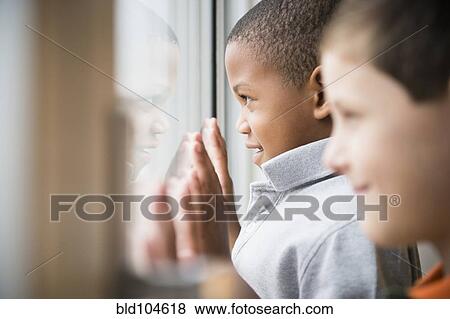 Stock Photo - Boys looking out window together. Fotosearch