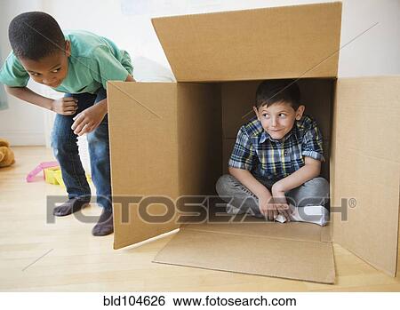 Stock Photograph - Boys playing with cardboard box. Fotosearch