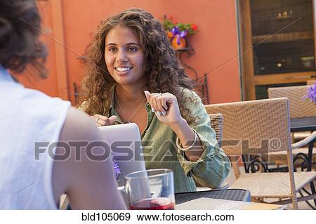 Stock Photo - Businesswomen having meeting in outdoor cafe. Fotosearch