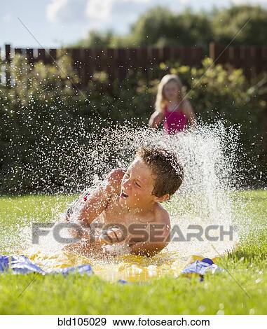 Caucasian boy sliding in water View Large Photo Image Stock Photo - Caucasian boy sliding in water. Fotosearch