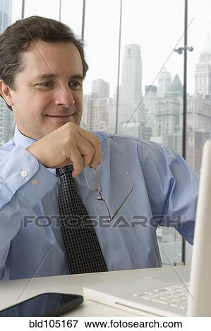 Stock Photo - Caucasian businessman working at desk. Fotosearch