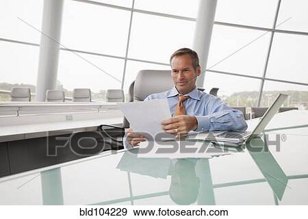 Stock Photo - Caucasian businessman working in conference room. Fotosearch