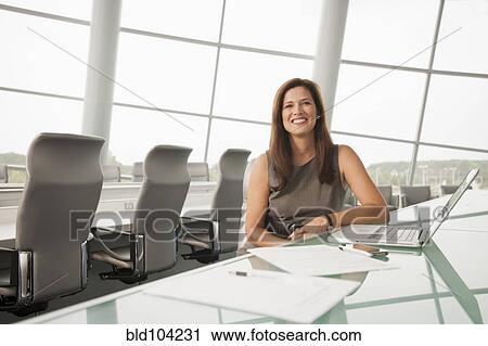 Stock Image - Caucasian businesswoman working in conference room. Fotosearch