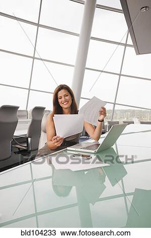 Stock Image - Caucasian businesswoman working in conference room. Fotosearch