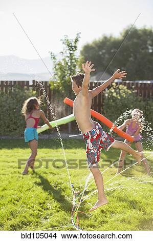 Caucasian children playing in the sprinkler View Large Photo Image Picture - Caucasian children playing in the sprinkler. Fotosearch