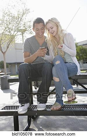 Stock Photo - Caucasian couple listening to music on mp3 player. Fotosearch