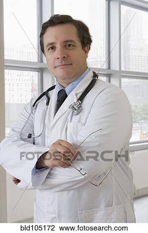 Stock Image - Caucasian doctor with arms crossed. Fotosearch
