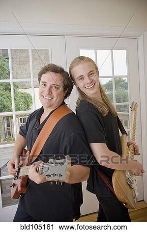 Caucasian father and son playing guitars View Large Photo Image Stock Image - Caucasian father and son playing guitars. Fotosearch