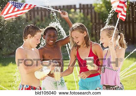 Stock Image - Caucasian friends drinking lemonade on Fourth of July. Fotosearch