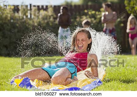 Stock Photo - Caucasian girl playing in water. Fotosearch