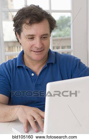 Caucasian man using laptop View Large Photo Image Stock Image - Caucasian man using laptop. Fotosearch