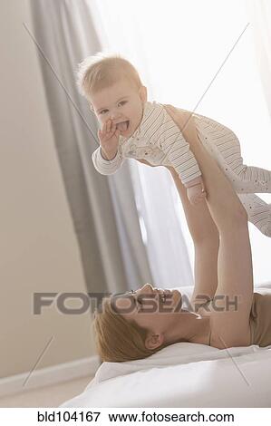 Caucasian mother lifting son View Large Photo Image Stock Photo - Caucasian mother lifting son. Fotosearch