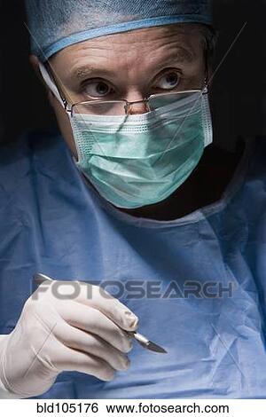 Stock Photograph - Caucasian surgeon performing surgery. Fotosearch