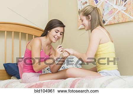 Stock Image - Caucasian teenage girls getting manicures. Fotosearch