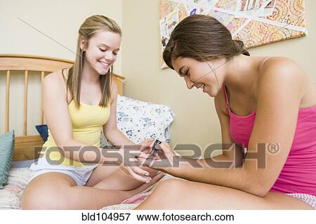 Stock Photo - Caucasian teenage girls getting manicures. Fotosearch