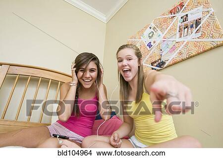 Picture - Caucasian teenage girls listening to music. Fotosearch