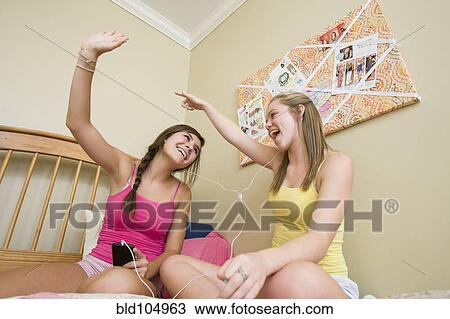 Stock Image - Caucasian teenage girls listening to music. Fotosearch