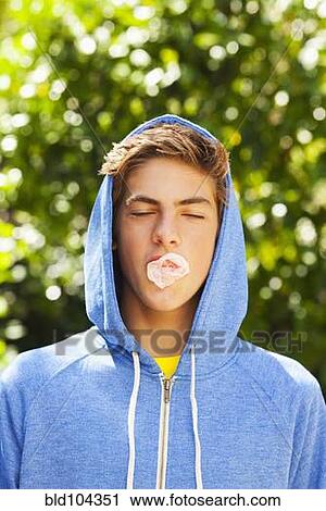 Stock Image - Caucasian teenager blowing bubble with gum. Fotosearch