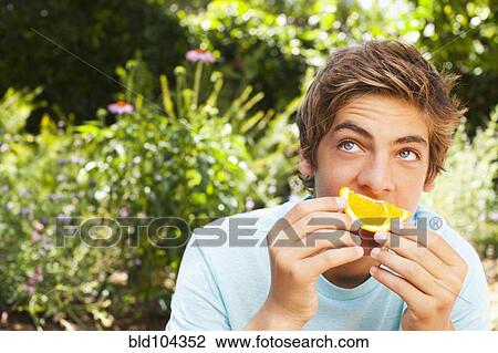 Caucasian teenager eating orange View Large Photo Image Stock Image - Caucasian teenager eating orange. Fotosearch