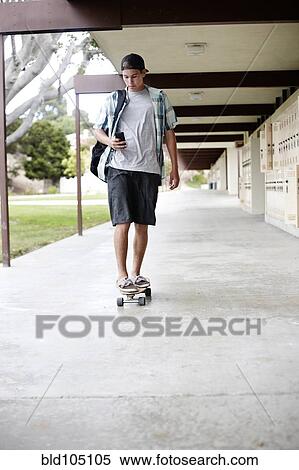 Stock Photography - Caucasian teenager riding skateboard. Fotosearch