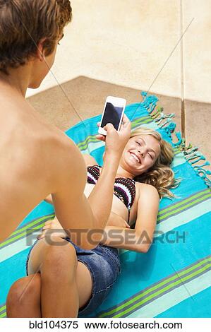 Caucasian teenager taking cell phone picture of girlfriend View Large Photo Image Stock Photography - Caucasian teenager taking cell phone picture of girlfriend. Fotosearch