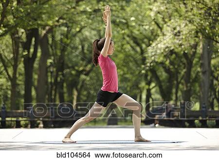 Picture - Caucasian woman practicing yoga in park. Fotosearch