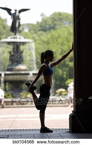 Stock Photograph - Caucasian woman stretching before exercise in park. Fotosearch