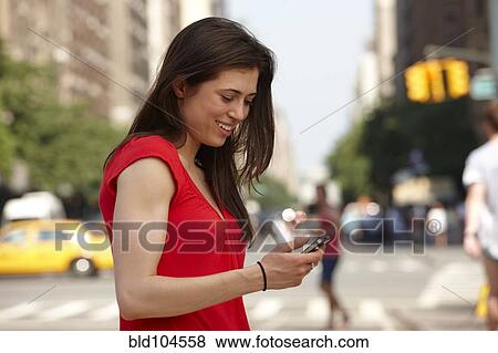 Caucasian woman using cell phone in city street View Large Photo Image Stock Photo - Caucasian woman using cell phone in city street. Fotosearch