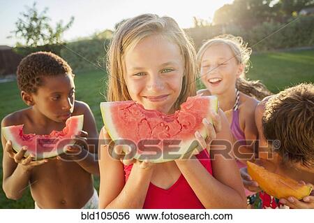 Stock Photograph - Children eating watermelon. Fotosearch
