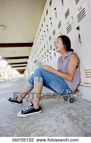 Chinese teenager on skateboard using digital tablet View Large Photo Image Stock Image - Chinese teenager on skateboard using digital tablet. Fotosearch