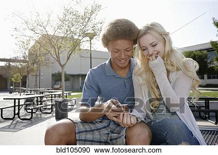 Stock Image - Couple looking at cell phone. Fotosearch