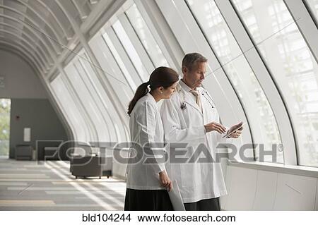 Picture - Doctors talking together in hospital corridor. Fotosearch