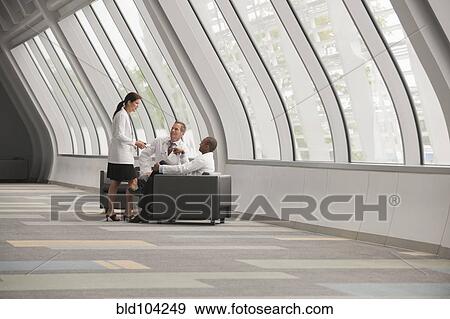 Doctors talking together in hospital corridor View Large Photo Image Stock Photo - Doctors talking together in hospital corridor. Fotosearch