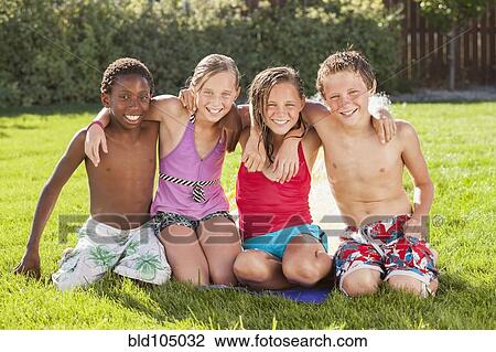 Stock Image - Friends hanging out together in yard. Fotosearch