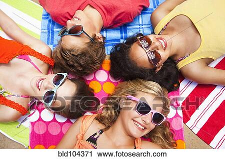 Stock Image - Friends laying outdoors together. Fotosearch