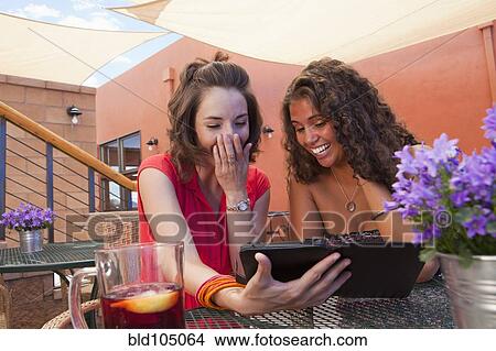 Picture - Friends looking at digital tablet together. Fotosearch