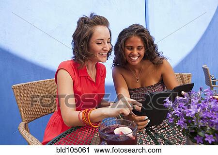 Friends looking at digital tablet together View Large Photo Image Stock Image - Friends looking at digital tablet together. Fotosearch