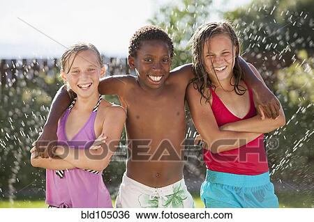 Stock Photograph - Friends playing in water. Fotosearch