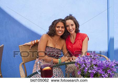 Friends sitting at patio table together View Large Photo Image Stock Image - Friends sitting at patio table together. Fotosearch
