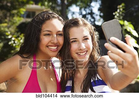 Picture - Friends taking self-portrait with cell phone. Fotosearch