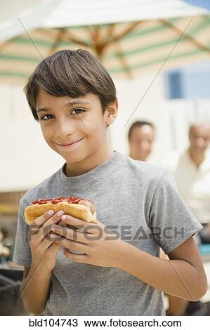 Hispanic boy eating hot dog View Large Photo Image Stock Image - Hispanic boy eating hot dog. Fotosearch