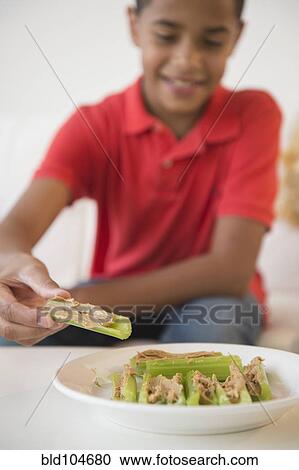 Hispanic boy eating peanut butter on celery View Large Photo Image Stock Image - Hispanic boy eating peanut butter on celery. Fotosearch