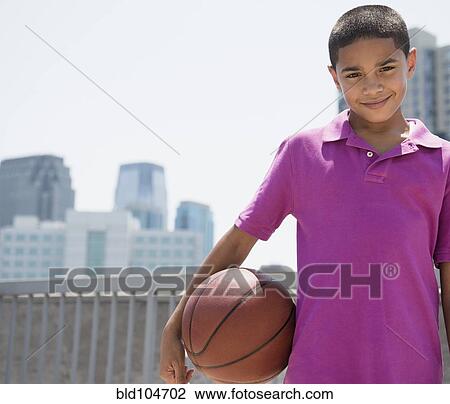 Stock Image - Hispanic boy holding basketball. Fotosearch