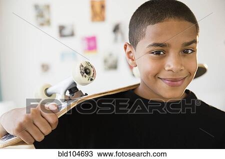 Hispanic boy holding skateboard View Large Photo Image Stock Image - Hispanic boy holding skateboard. Fotosearch
