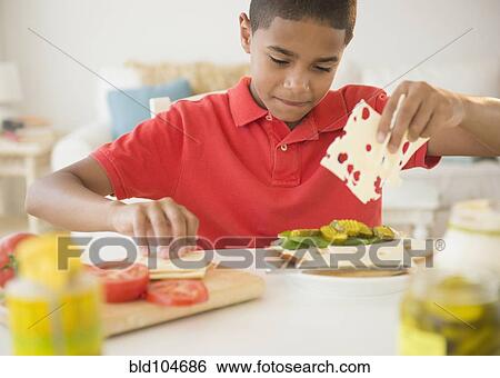 Stock Photograph - Hispanic boy making sandwich. Fotosearch