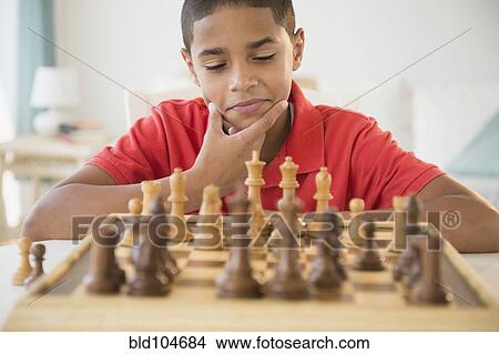 Picture - Hispanic boy playing chess. Fotosearch
